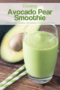 an avocado smoothie in a glass with a green straw next to it