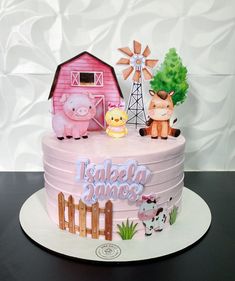 a pink cake with farm animals on it