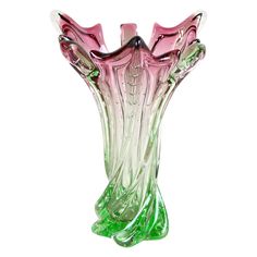 a pink and green glass vase sitting on top of a table