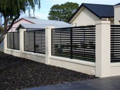 a white fence with black slats on the top and bottom, next to a tree