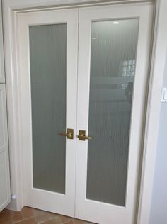 two white doors with frosted glass on the front and back sides in a room