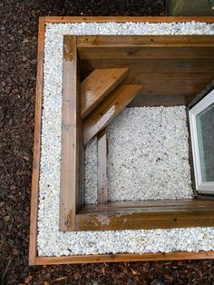 an overhead view of a wooden bench with gravel and rocks on the ground next to it