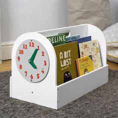 a white clock with books in it on the floor