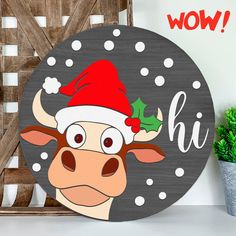 a cow with a santa hat on it's head is standing in front of a sign