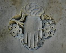 a close up of a carving on the side of a building with flowers around it