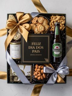 a bottle of beer and snacks in a gift box with gold ribbon on the side