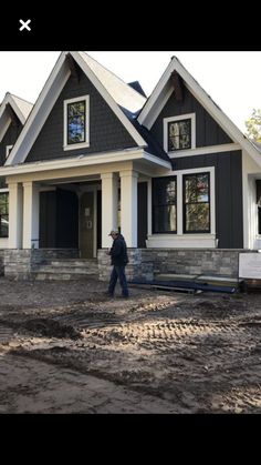 a man walking in front of a house under construction