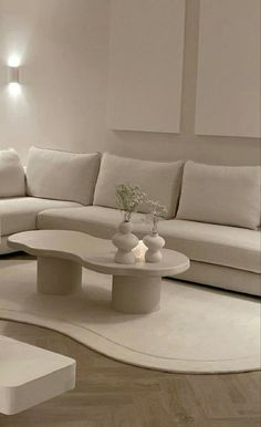 a modern living room with white furniture and wood flooring