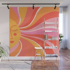 an orange and pink wall mural with a woman's face in the sun on it