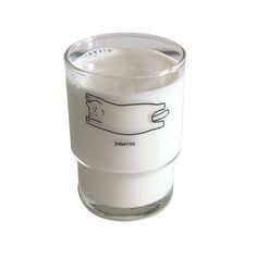 a glass filled with milk on top of a white surface