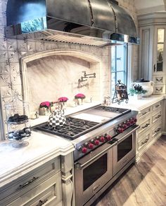 a kitchen with an oven, stove and counter tops in white marbled wood flooring