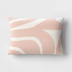 a pink and white pillow sitting on top of a gray wall