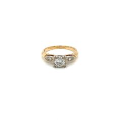 a yellow gold ring with two diamonds on the sides and a single diamond in the middle