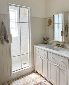 a bathroom with white cabinets and marble counter tops