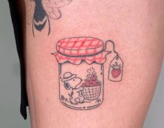 a person with a tattoo on their leg that has a jar and strawberries in it