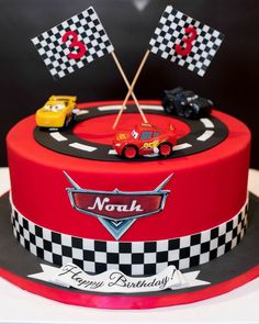 a birthday cake decorated with cars and flags