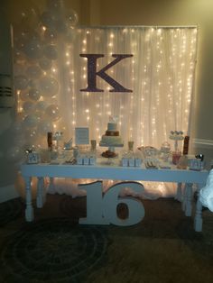 the table is set up for a party with balloons and decorations on it, including a large letter k