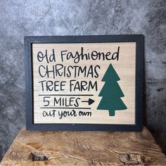 an old fashioned christmas tree farm sign is displayed on a piece of wood with the words cut your own