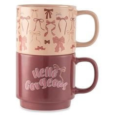 two coffee mugs with bows on them, one is pink and the other has brown