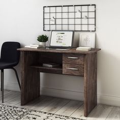 a desk with a computer on top of it next to a black chair and rug