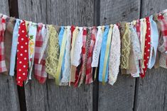 a close up of many different colored ribbons on a wooden fence with polka dots and laces