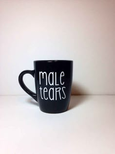 a black coffee mug with the words male tears written on it