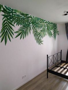 a bedroom with a bed, window and palm leaf wall decal on the wall