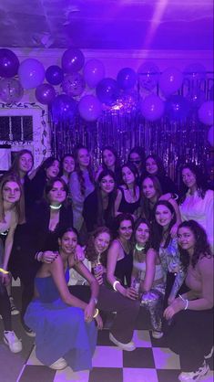 a group of young women posing for a photo in front of balloons and streamers