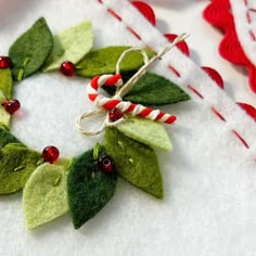 a christmas wreath made out of felt with candy canes and holly leaves on it