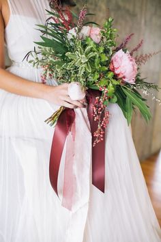 a bride holding a bouquet of flowers in her hands