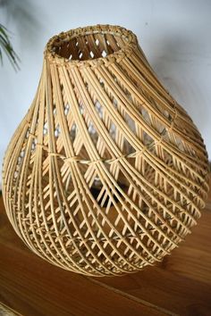 a wicker vase sitting on top of a wooden table