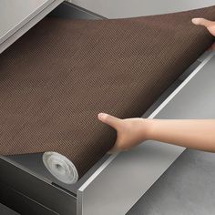 a person reaching for a roll of tape on top of a drawer