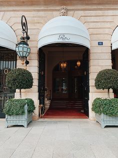 an entrance to a hotel with potted plants