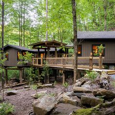 a house in the woods surrounded by rocks and trees