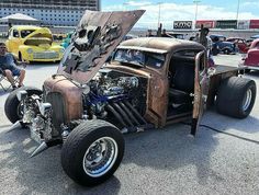 an old hot rod car is parked in a parking lot