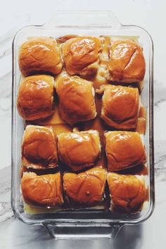 baked rolls in a glass baking dish on a marble counter top, ready to be eaten