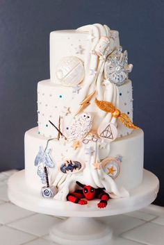 a three tiered white cake with lots of different things on it