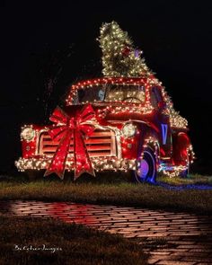 an old red truck decorated with christmas lights