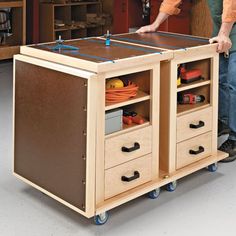 a man standing next to a workbench with drawers