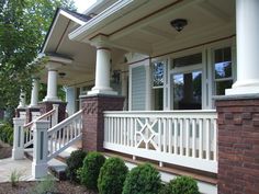 the front porch of a house with white pillars