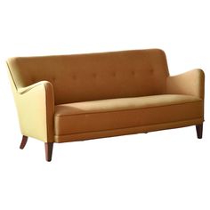 a brown and tan couch sitting on top of a white floor