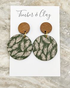 a pair of wooden earrings with palm leaves on them