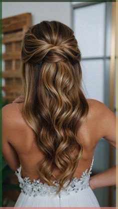 the back of a woman's head with long, wavy hair in her wedding dress