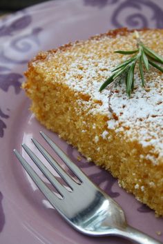 a piece of cake with powdered sugar on top and a fork next to it