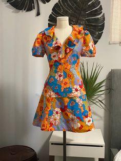 Fun groovy flower power print in orange, blue, purple  Possibly handmade no tags  Two piece set: Mini skirt with A line silhouette  Side zip and button at waist  Skirt is lined  Approx measurements flat: Waist 13.74" Hips 22.5" Length 18" Top Ruffle neckline Puff sleeves  Zip back and tie back at waist  Approx measurements flat: Pit to pit 18.5" Waist 15.75" Length 24" Top is lined  Flaws: A few small spots see pictures Two Piece Set, Dress Clothes For Women, Tie Back, Puff Sleeves, Vintage 70s, Blue Purple, Flower Power, Waist Skirt, Side Zip