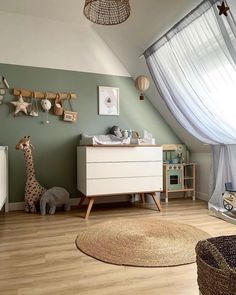 a baby's room is decorated in green and white with wooden toys on the floor