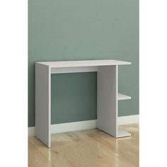 a small white desk against a green wall