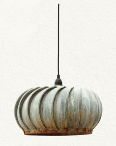 a hanging light made out of metal and wood with an unusual design on the top