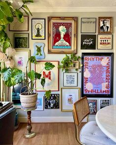 a living room filled with lots of pictures and plants