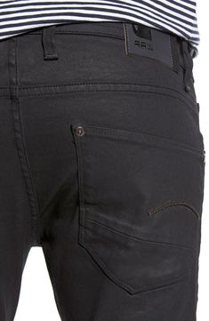 G-Star Raw's skinniest close-fitting jeans are made from wax-coated black stretch denim with a luster brought out by naturally worn creases. Asymmetrical black pockets with leather trim finish the look. 31 1/2" inseam; 12" leg opening; 9" front rise; 14 1/2" back rise (size 32). Zip fly with button closure. Five-pocket style. 98% cotton, 2% elastane. Dry clean or machine wash cold, line dry. By G-Star Raw; imported. Denim @ the Men's Shop. Black Rigid Denim Jeans For Streetwear, Washed Black Rigid Denim Jeans, Black Rigid Denim Jeans, G Star Raw Men Jeans, G Star Raw Jeans, Luxury Dark Wash Men's Jeans, Fitted Coat, G Star Raw, Designer Jeans